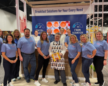 Group of General Mills Foodservice employees standing in front of event booth