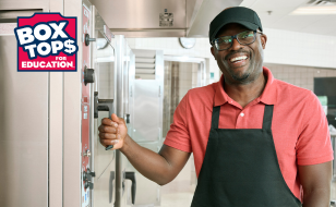 Operator in the kitchen smiling with the Box Tops for Education logo in corner 