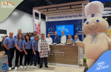 A group of general mills employees posing with a an inflatable Pillsbury dough boy at a food convention