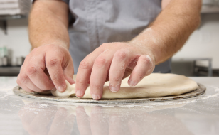 A Close up of a person making the dough edges.