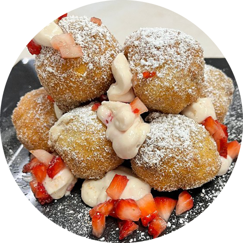 Biscuit bites with strawberries, cream, and powdered sugar