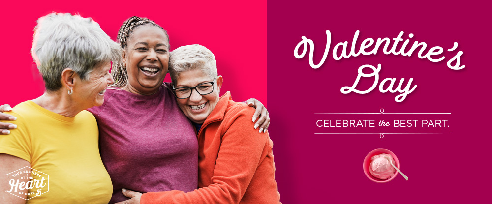 Valentine’s Day. Celebrate the Best Part. Your Business is at the Heart of Ours logo. Strawberry mousse on dark pink background. Three smiling senior women hugging on a bright pink background.